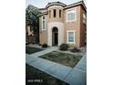 A two-story home with a circular tower and light-colored stucco, small front lawn and sidewalk at 4313 E Jasper Dr, Gilbert, AZ 85296