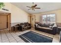 Comfortable living room with vaulted ceilings, tile floors, comfortable brown couches and dark accents at 6936 W Monterey Way, Phoenix, AZ 85033