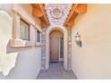 Arched doorway with stone detail, exterior lantern, and brick pathway creating a welcoming entrance at 6937 E Sierra Morena Cir, Mesa, AZ 85207