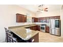 Spacious kitchen featuring stainless steel appliances, granite countertops, and a breakfast bar area at 6937 E Sierra Morena Cir, Mesa, AZ 85207
