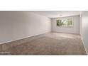 Spacious carpeted living room with a large window offering natural light, perfect for relaxation and entertaining at 7126 N 29Th Dr, Phoenix, AZ 85051
