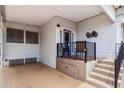 View of the covered front porch and seating area featuring an epoxy floor, storage, and steps to the entry door at 7750 E Broadway Rd # 538, Mesa, AZ 85208