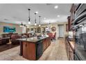 Modern kitchen featuring dark cabinets, island and stainless steel appliances, adjacent to the living area at 13131 N 153Rd Ave, Surprise, AZ 85379