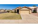 Charming single-story home featuring a well-maintained lawn and a two-car attached garage at 1350 E Vaughn Ave, Gilbert, AZ 85234