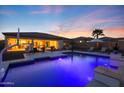Gorgeous swimming pool with custom lighting, an umbrella, and an inviting patio with lounge chairs at 14979 S 184Th Ave, Goodyear, AZ 85338