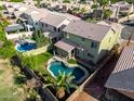 An aerial view of a home with a private pool, patio area, lush lawn, and mature palm trees, perfect for outdoor living at 1560 E Flint St, Chandler, AZ 85225