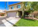 Charming two-story home features a lush front lawn, attached two car garage, and well-manicured landscaping at 1560 E Flint St, Chandler, AZ 85225