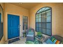 Cozy porch with comfortable seating, a vibrant blue door, and an arched window at 17323 E Teal Dr, Fountain Hills, AZ 85268
