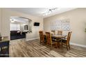 Open dining room with wood-look tile floors, pendant lighting, and access to the living room at 1926 S Longspur Ln, Gilbert, AZ 85295