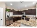 Charming kitchen featuring stainless steel appliances, granite countertops, and dark wood cabinets at 1926 S Longspur Ln, Gilbert, AZ 85295
