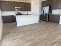 Modern kitchen features stainless steel appliances, a center island, and dark brown cabinets at 22368 W Monona Ln, Surprise, AZ 85387