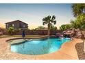 Beautiful backyard pool with a rock waterfall feature and lush landscaping at 2257 E Redwood Ct, Chandler, AZ 85286