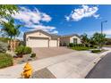 Single-story home with a spacious three-car garage, desert landscaping, and a brick-paved driveway and front entryway at 25875 S 227Th Way, Queen Creek, AZ 85142