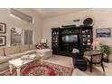 Bright living room featuring tile floors, comfortable seating, a large entertainment center, and a vaulted ceiling at 2926 N 149Th Dr, Goodyear, AZ 85395