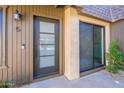 Exterior view of front door with black frame, a glass inset, a modern handle and a Ring doorbell on the wood-look siding at 3033 N 39Th St # 5, Phoenix, AZ 85018