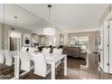 Elegant dining area with a sleek white table, modern chairs, and a mirrored wall reflecting the living space at 4600 N 68Th St # 302, Scottsdale, AZ 85251