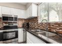 Well-equipped kitchen featuring stainless steel appliances, dark countertops, and a decorative backsplash at 4600 N 68Th St # 302, Scottsdale, AZ 85251