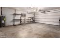 Garage features a white door, shelving units, concrete flooring, and plenty of storage space at 5055 E Enid Ave, Mesa, AZ 85206