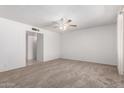 Spacious living room with neutral carpeting, a ceiling fan, and a doorway leading to other rooms at 5055 E Enid Ave, Mesa, AZ 85206