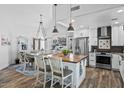 Modern kitchen and dining area featuring wood floors, pendant lighting, a wine refrigerator, and stainless steel appliances at 526 W Kings Ave, Phoenix, AZ 85023