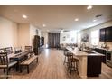Open-concept living area with wood-look tile flooring and seamless flow to the kitchen at 5726 W Atlantis Way, Phoenix, AZ 85043