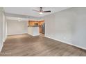 Spacious open-concept living room with wood floors, access to the kitchen, and lots of natural light at 5757 W Eugie Ave # 1076, Glendale, AZ 85304