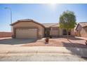 Tan single-story home featuring low maintenance desert landscaping and a two car garage at 6984 S Newport Ct, Chandler, AZ 85249