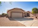 Tan single-story home featuring low maintenance desert landscaping and a two car garage at 6984 S Newport Ct, Chandler, AZ 85249