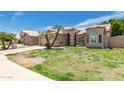 Home exterior featuring arched entry, two-car garage, and manicured lawn at 705 W Country Estates Ave, Gilbert, AZ 85233