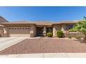 Charming single-story home featuring a two-car garage and desert landscaping at 15288 W Redfield Rd, Surprise, AZ 85379