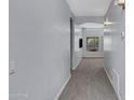 Neutral hallway leads to a living area, showcasing light gray walls, plush carpeting, and tasteful lighting at 1650 S Crismon Rd # 86, Mesa, AZ 85209