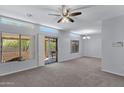 Spacious living room featuring large windows, access to a patio, neutral carpet, and modern light fixtures at 1650 S Crismon Rd # 86, Mesa, AZ 85209
