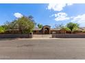 Charming single-story home featuring a brick facade, gated entrance, and mature trees, offering both privacy and curb appeal at 2043 E Quartz St, Mesa, AZ 85213
