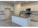 Bright kitchen features white cabinetry, stainless steel appliances, granite countertops and an island with black faucet at 20615 N 226Th Dr, Surprise, AZ 85387