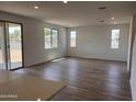 Spacious living room features wood-look tile floors, neutral paint, and bright natural light at 22359 W Monona Ln, Surprise, AZ 85387
