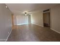 Bright living room featuring tile floors, a ceiling fan, and sliding glass doors at 2401 W Weldon Ave, Phoenix, AZ 85015