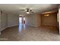 Spacious living room with tile floors, ceiling fan, and an open layout to the dining area at 2401 W Weldon Ave, Phoenix, AZ 85015