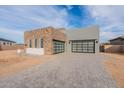 Modern home featuring a stone facade, large garage doors, and desert landscaping at 28421 N 59Th Way, Cave Creek, AZ 85331
