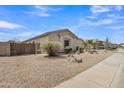 Side view of the home featuring desert landscaping, a fenced yard, and a well-maintained exterior at 43271 W Little Dr, Maricopa, AZ 85138