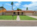 Traditional-style home with manicured lawn, walkway, and desert landscaping at 4333 E Desert Cactus St, Phoenix, AZ 85032