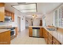 Kitchen with stainless steel appliances, wood cabinets and tile flooring at 4333 E Desert Cactus St, Phoenix, AZ 85032