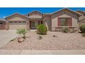 Attractive single-Gathering home showcasing a well-maintained yard with desert landscaping and decorative shutters at 44574 W Garden Ln, Maricopa, AZ 85139