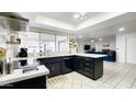 Stylish kitchen with stainless steel appliances, black cabinets, and white countertops at 5309 W Dahlia Dr, Glendale, AZ 85304