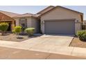 Attractive single-Gathering home with manicured landscaping and a gray two-car garage door at 7343 W Hughes Dr, Phoenix, AZ 85043