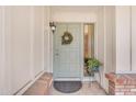 Inviting entryway featuring a decorative wreath, a stylish light fixture, and a potted plant adding a touch of greenery at 928 W Natal Ave, Mesa, AZ 85210