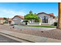 Traditional style home with lush landscaping and a driveway leading to a two-car garage at 10102 E Dreyfus Ave, Scottsdale, AZ 85260