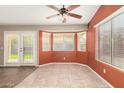 Cozy living room with tiled floor, bay windows, ceiling fan and sliding glass doors to backyard at 1138 E Avenida Isabela St, Casa Grande, AZ 85122
