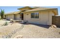 Home exterior showcasing desert landscaping, rock features and a wall detail in the yard at 11447 E Mendoza Ave, Mesa, AZ 85209