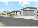 View of multiple grey single-story homes, each with a two-car garage and manicured lawns at 1160 E Cedar Pl, Chandler, AZ 85249