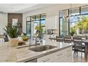 Bright, modern kitchen features a marble island, stainless steel faucet, and backyard view at 1160 E Cedar Pl, Chandler, AZ 85249